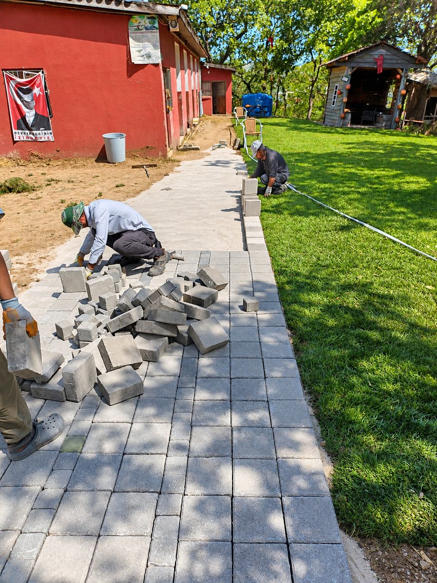 Bursa parke taşı döşeme: Uzgur Botanik ekibi çim kenarında kilitli parke taşı yol döşüyor