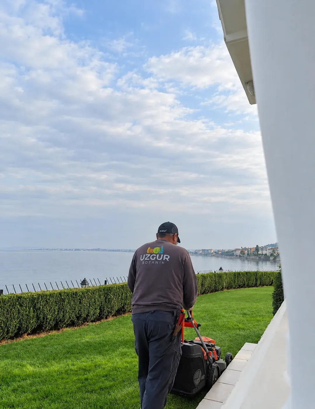 Mudanya'da deniz kenarındaki villa bahçesinde Uzgur Botanik ekibi çim biçiyor